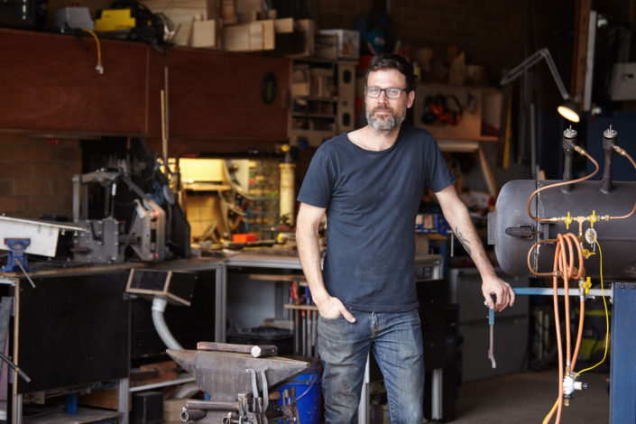 Robert Trimarchi custom knife maker standing in his workshop Melbourne commercial photographer